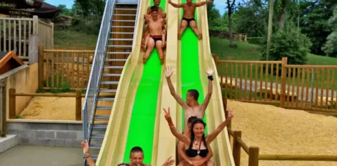 Camping Des Chênes Verts : toboggan vert avec des visiteurs en train de descendre.