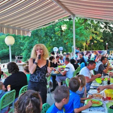 Femme chantant devant une foule au Camping Des Chênes Verts