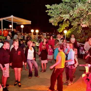 Photo camping Des Chênes Verts soirée avec groupe dansant sous projecteur