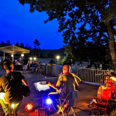 Musiciens jouant sous les arbres le soir au Camping Des Chênes Verts