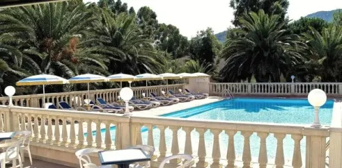 Terrasse avec parasols, chaises longues et piscine entourée de palmiers, Camping Résidence Thalassa
