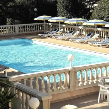 Piscine avec chaises longues et parasols jaunes au Camping Résidence Thalassa