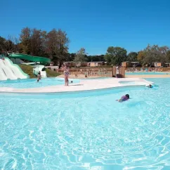 Personnes dans la piscine près d'un toboggan blanc au Camping Le Vorlen