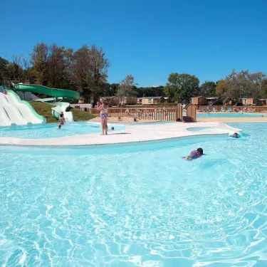 Personnes dans la piscine près d'un toboggan blanc au Camping Le Vorlen