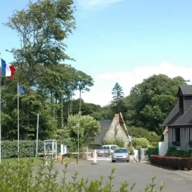 Camping Etennemare : entrée avec drapeaux français et maison traditionnelle