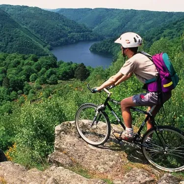 Camping Logis de Séchemailles : cycliste sur rocher avec lac en arrière-plan