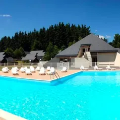 Piscine bleue avec chaises longues blanches autour, camping Logis de Séchemailles