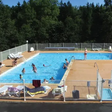 Personnes nageant dans la piscine entourée d'arbres au Camping Logis de Séchemailles