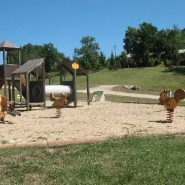 Camping Le Bosquet 12 - aire de jeux pour enfants avec montagnes russes et sauteurs animés.