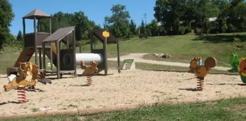 Camping Le Bosquet 12 - aire de jeux pour enfants avec montagnes russes et sauteurs animés.