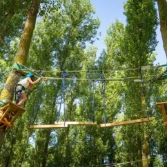 Deux personnes faisant de l'escalade en forêt au Camping Le Bosquet 12.
