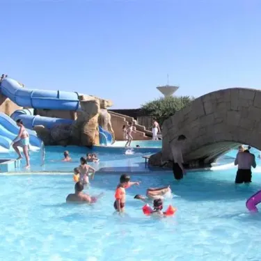 Camping Acapulco - enfants et adultes dans une piscine avec pont en pierre