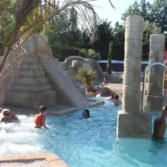 Camping Acapulco - piscine avec structures en pierre et toboggan de style antique