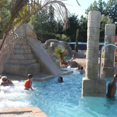 Camping Acapulco - piscine avec structures en pierre et toboggan de style antique