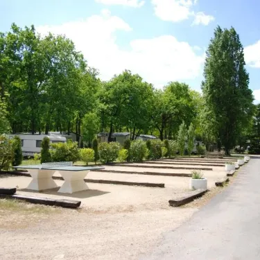 Emplacement du camping avec caravanes, tables et bancs en plein air