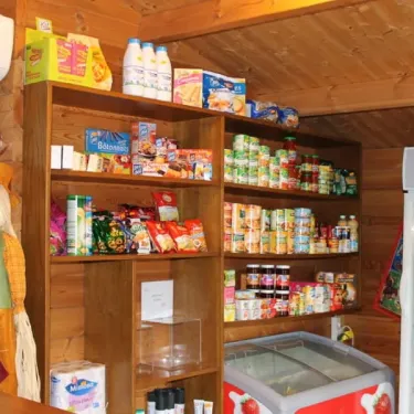 Magasin de provisions dans le camping Les Acacias - 37, avec des produits alimentaires sur les étagères et une figurine d'automne.