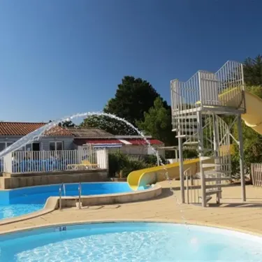 Toboggan jaune et fontaine d'eau dans la piscine du Camping Le Parc de la Grève