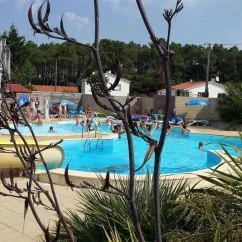 Vue du camping avec piscine, toboggan et visiteurs autour du Camping Le Parc de la Grève