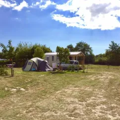 Tente et mobile home au Camping Au Pré de l'Etang sous un ciel bleu.