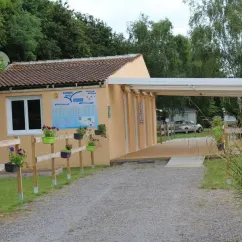 Camping La Vertonne - entrée avec bâtiments et fleurs en pots