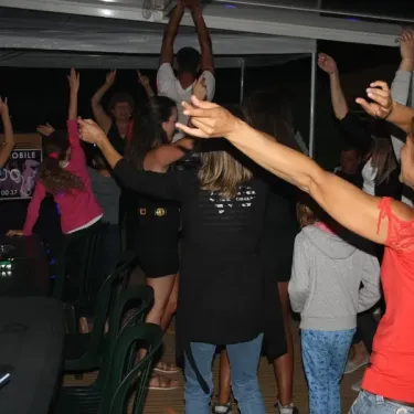 Camping La Vertonne : groupe dansant sous une tente illuminée