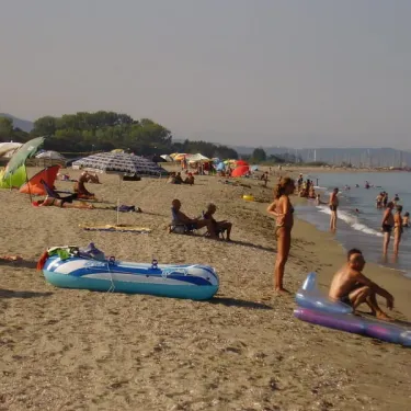 Camping Olmello Plage - plage animée avec parasols, personnes dans l'eau et sur le sable