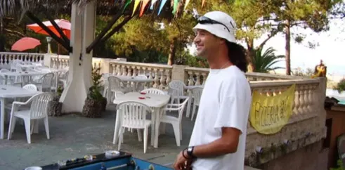 Homme jouant au football sur table dans un espace extérieur du Camping Olmello Plage