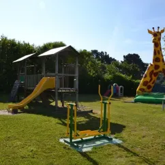 Parc infantile avec toboggan et girafe gonflable au Camping La Mer Blanche