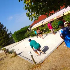 Camping Quercy Vacances : jeu de boules sur une aire en plein air sous un arbre.