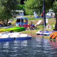 Paddle boats et kayaks alignés près d'un kiosque au Camping Le Rouquié du Lac