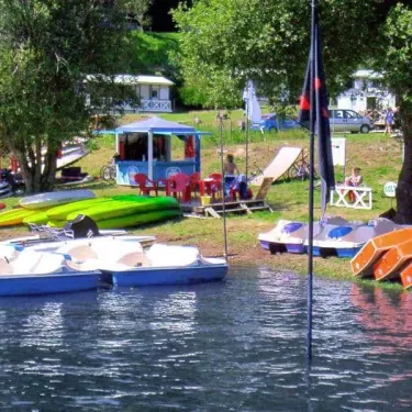 Paddle boats et kayaks alignés près d'un kiosque au Camping Le Rouquié du Lac