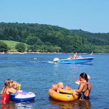Enfants dans l'eau avec des flotteurs au Camping Le Rouquié du Lac