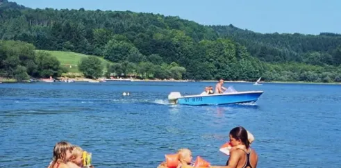 Enfants dans l'eau avec des flotteurs au Camping Le Rouquié du Lac