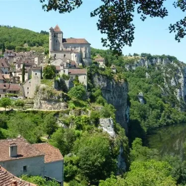 Vue panoramique du village de Camping La Sole avec église et rivière en contrebas.