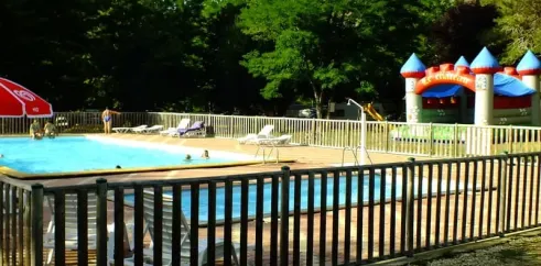 Piscine avec parasol et jeux pour enfants au Camping Le Trel