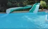 Piscine avec toboggan vert et blanc au Camping Les Bö-Bains