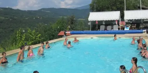 Camping Le Champ Long : piscine avec des visiteurs et vue sur les collines