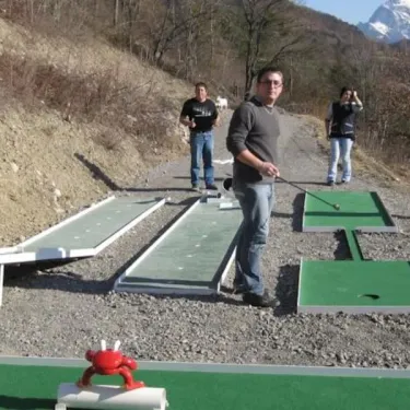 Mini-golf en extérieur au Camping Le Champ Long avec montagnes en arrière-plan