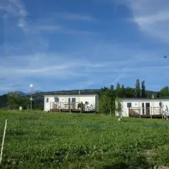 Cabanes mobiles dans un parc verdoyant à Camping Le Champ Long