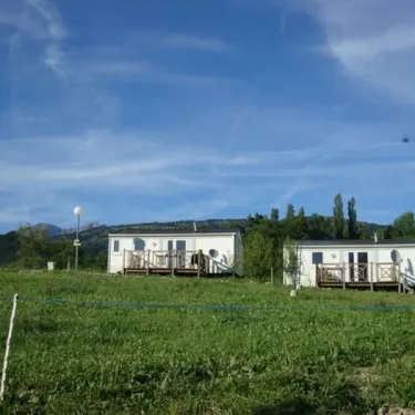 Cabanes mobiles dans un parc verdoyant à Camping Le Champ Long