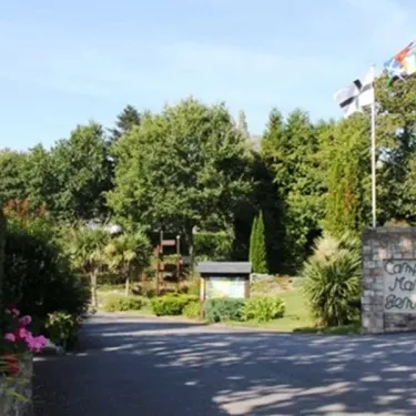 Camping du Manoir de Penn Ar Ster : entrée avec arbres et drapeaux