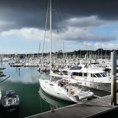 Port avec des voiliers amarrés sous un ciel nuageux, près du Camping du Manoir de Penn Ar Ster