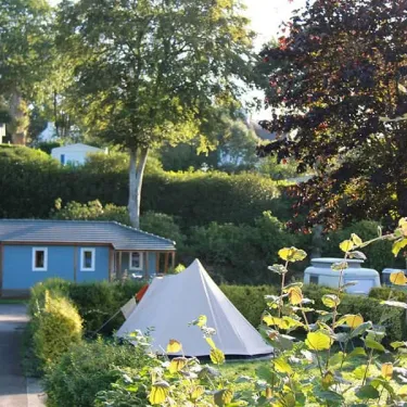 Tente et cabane bleue au milieu d'arbres