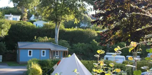 Tente et cabane bleue au milieu d'arbres