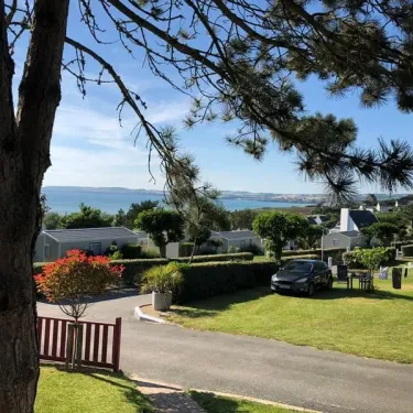 Village de camping avec mobile homes et voiture près d'une route, vue depuis un arbre