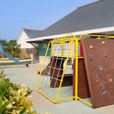 Parc d'activités pour enfants avec toboggan et mur d'escalade au Camping Emeraude.