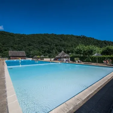 Piscine extérieure entourée de parasols et de chaises longues, Camping Le Gibanel