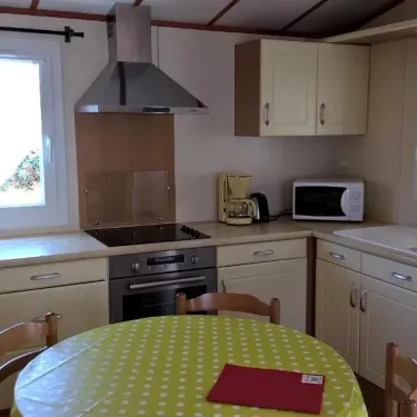 Cuisine équipée avec table, four, micro-ondes et réfrigérateur - Chalet Grand Confort - Domaine de L'Auzance
