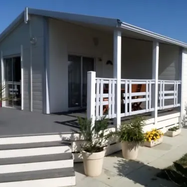 Chalet Prestige 2 Chambres TC - Domaine de L'Auzance : extérieur avec véranda et pots de fleurs