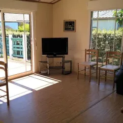 Chalet Prestige 3 Chambres T - Domaine de L'Auzance : salon avec télévision et chaises en bois